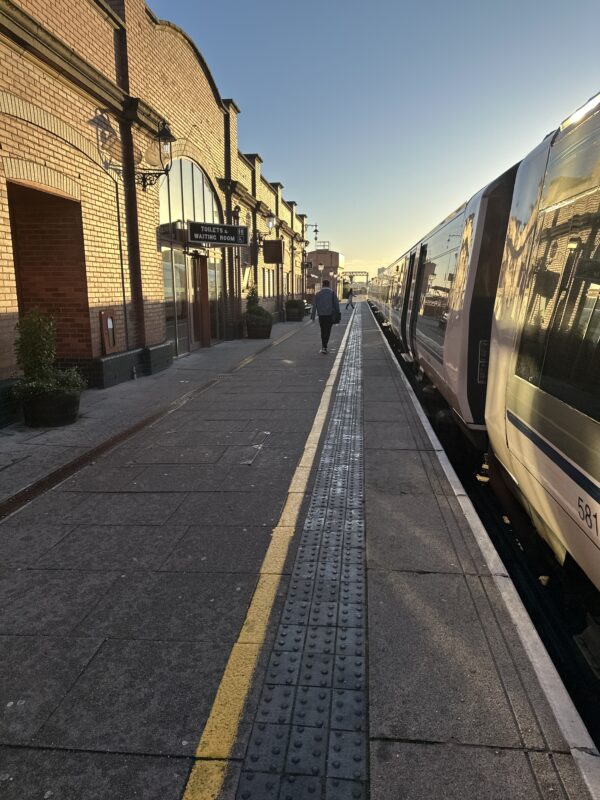 a person walking on a platform next to a train