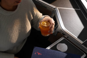 a person holding a glass of orange juice