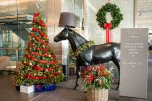 a statue of a horse with a lamp on its head next to a christmas tree