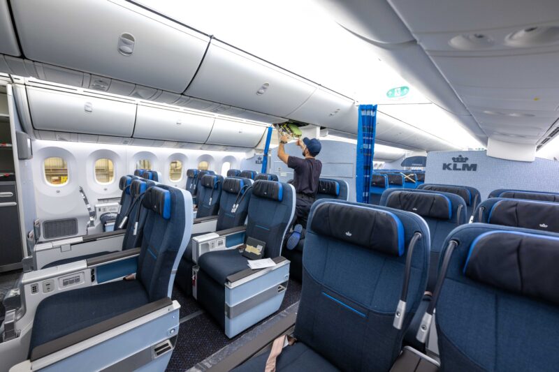 a man cleaning the ceiling of an airplane