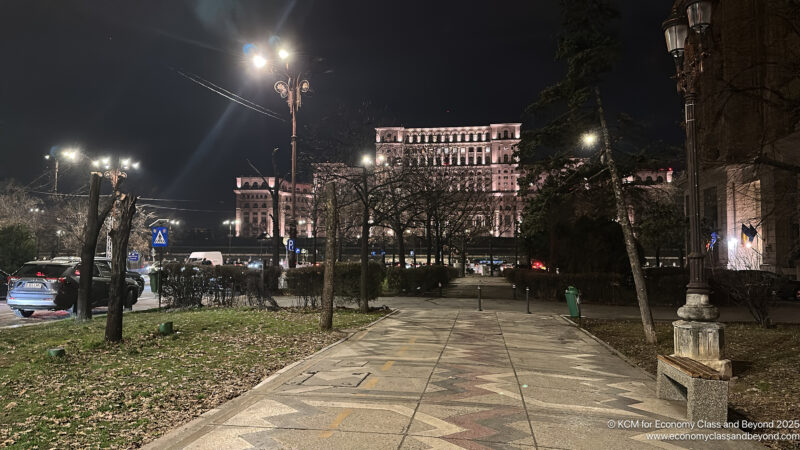 a walkway with trees and a building in the background