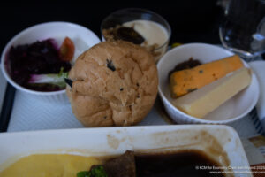 a plate of food with a roll of bread and cheese