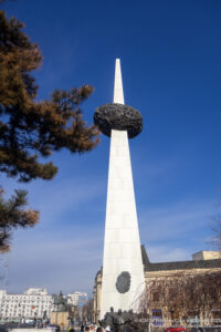 a tall white tower with a black object in the middle