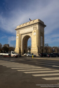 a large stone arch with a flag on top