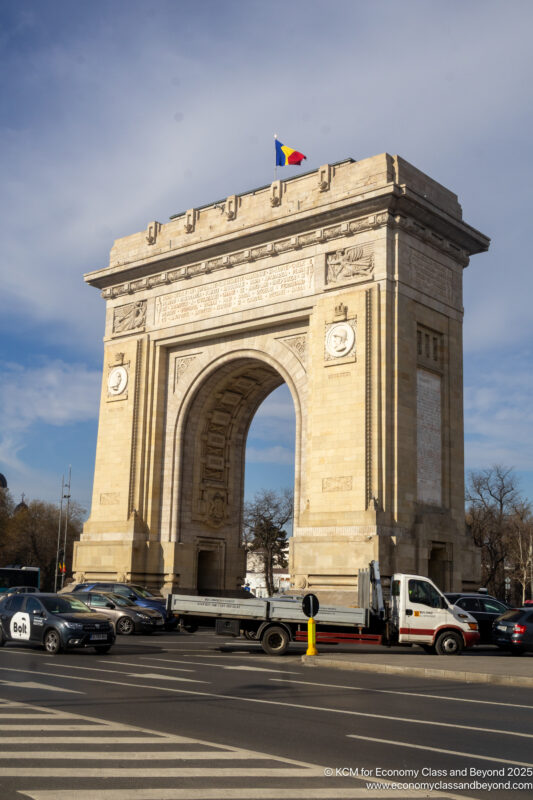 a large stone arch with a flag on top