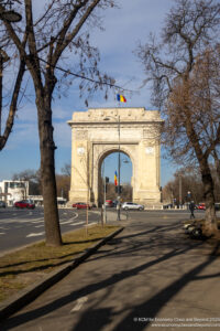 a stone arch with flags on top of it