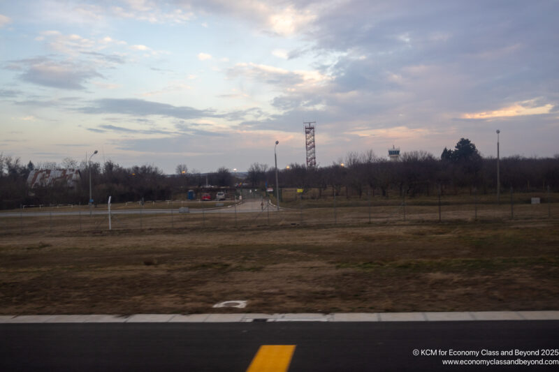 a field with trees and a tower in the background