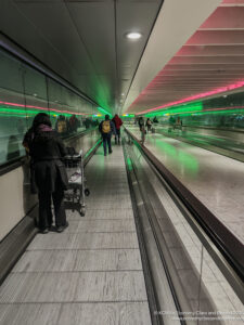 people walking down a walkway with a trolley