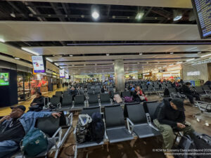 people sitting in chairs in an airport