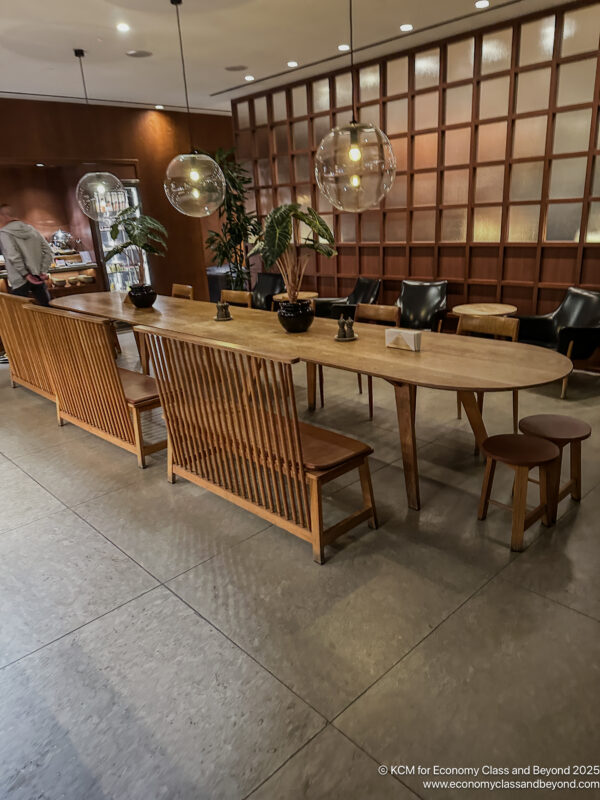 a long table with chairs and a man standing in the background