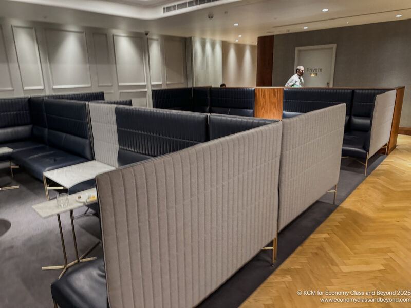 a room with a few booths and a man standing behind it