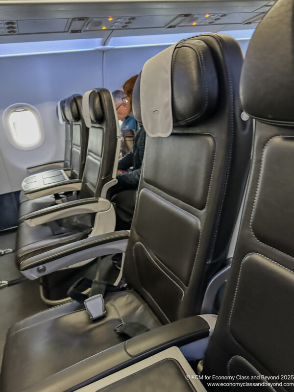 a row of black chairs on an airplane