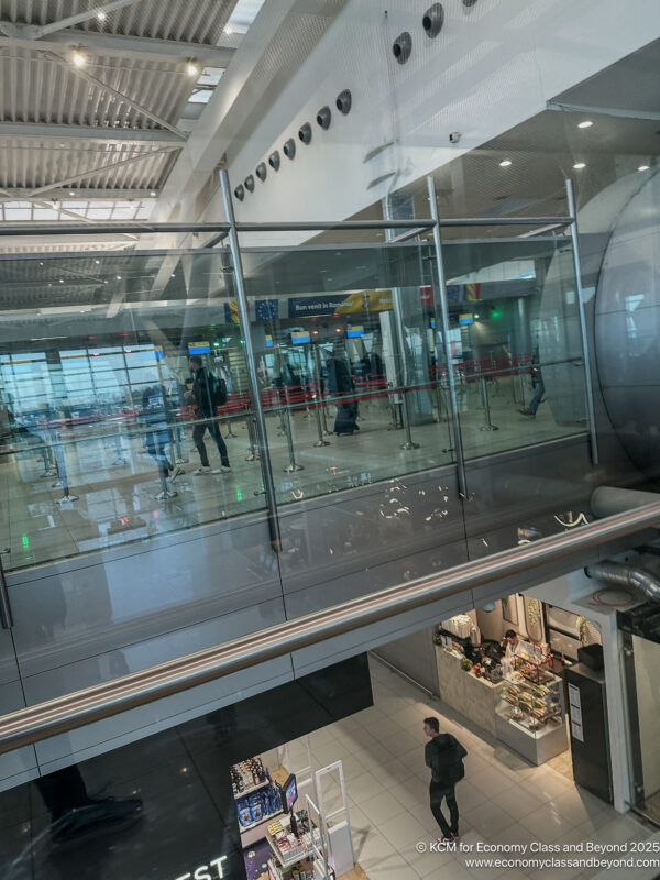 a glass wall with people walking in the middle