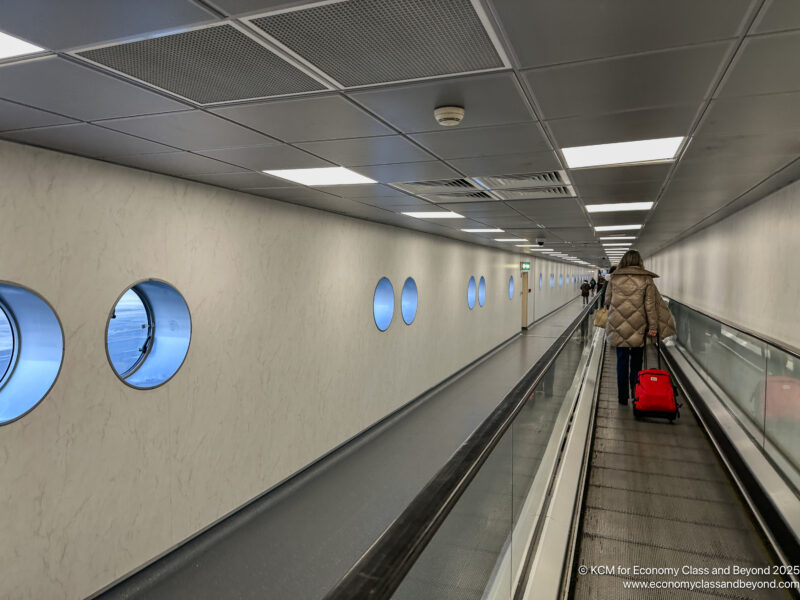 a person with a suitcase on a moving walkway