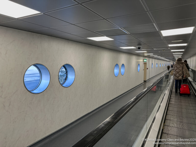 a walkway with windows and a man walking on it