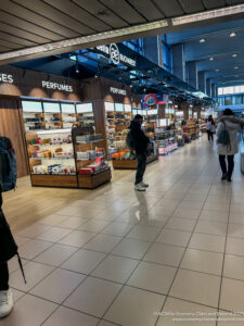 people inside a building with shelves of perfumes