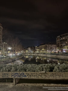a river with buildings and trees at night