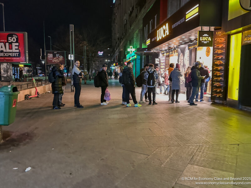 a group of people standing in a line outside a store