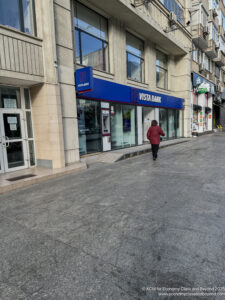 a woman walking on a sidewalk in front of a building