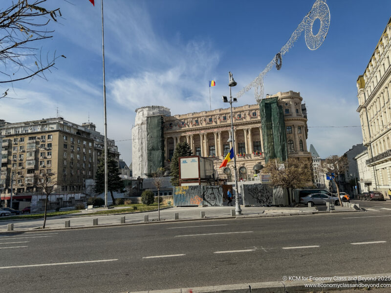 a street with a large building and flags