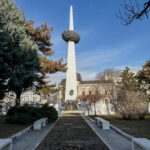 a white tower with a circular object in the middle