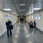 a woman and children walking in a hallway