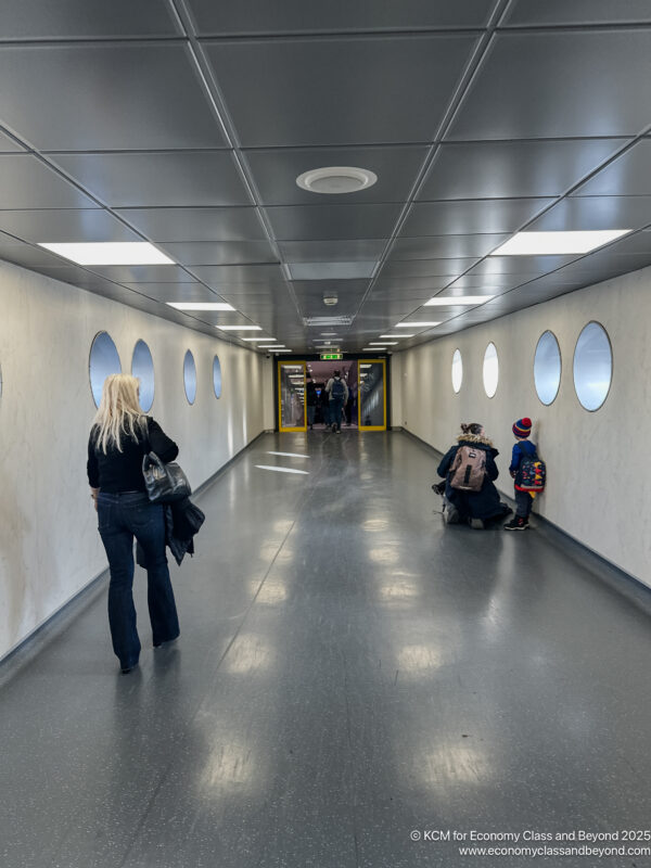 a woman and children walking in a hallway