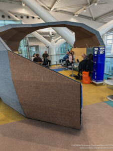 a group of people sitting in a room with a large structure
