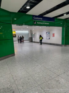 people in a hallway with a sign and people walking