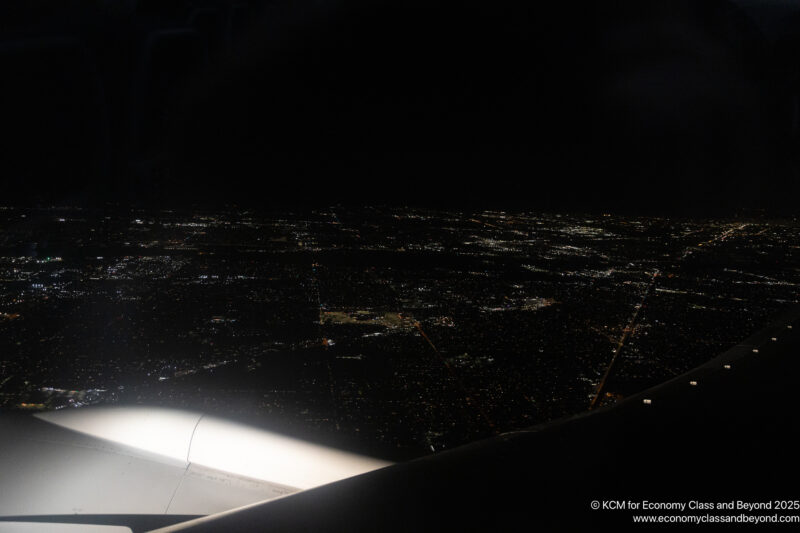 an airplane wing and a city at night