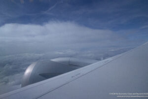 an airplane wing with clouds in the background