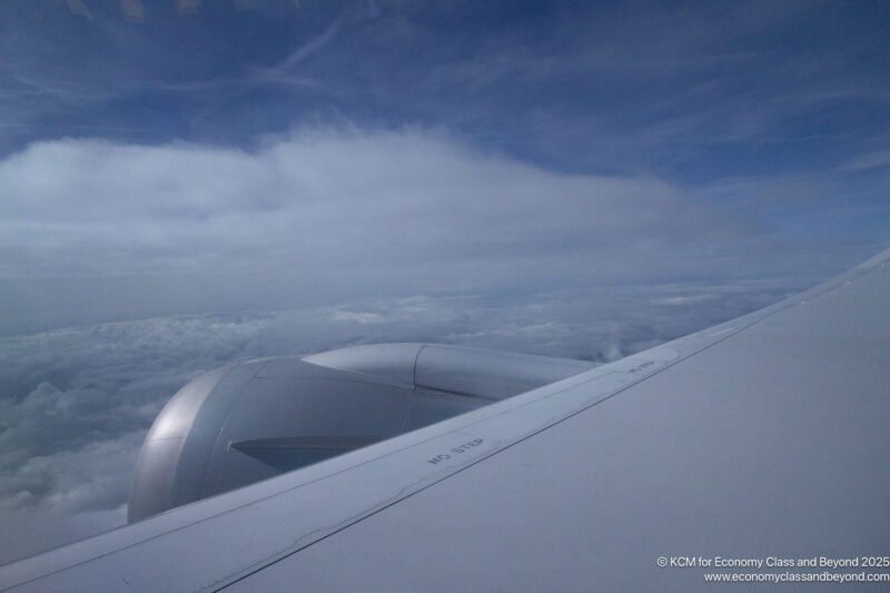 an airplane wing with clouds in the background