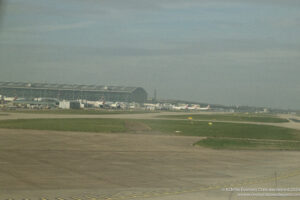 an airport with a large building and grass