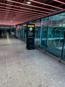 a glass wall with a sign in the middle of a hallway