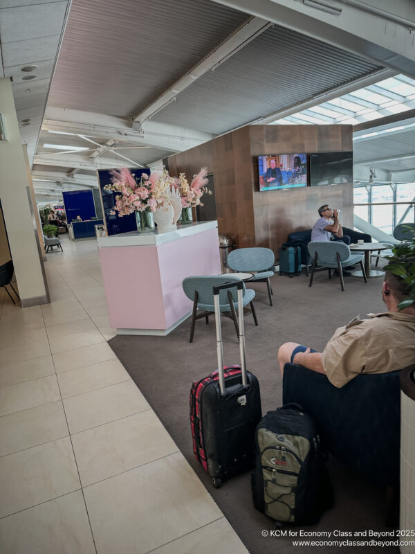 a man sitting in a chair with luggage in a lobby
