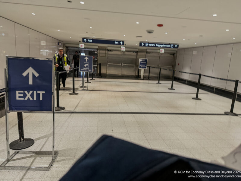 a man standing in a hallway with a sign