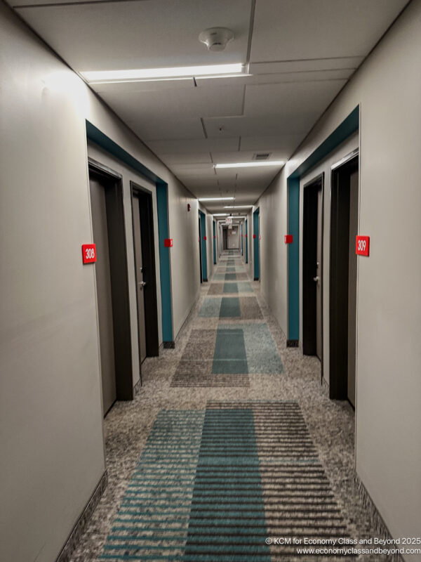 a long hallway with doors and a carpeted floor