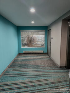 a hallway with a window and a blue wall