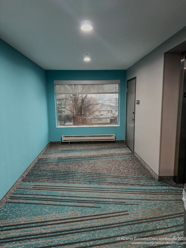 a hallway with a window and a blue wall