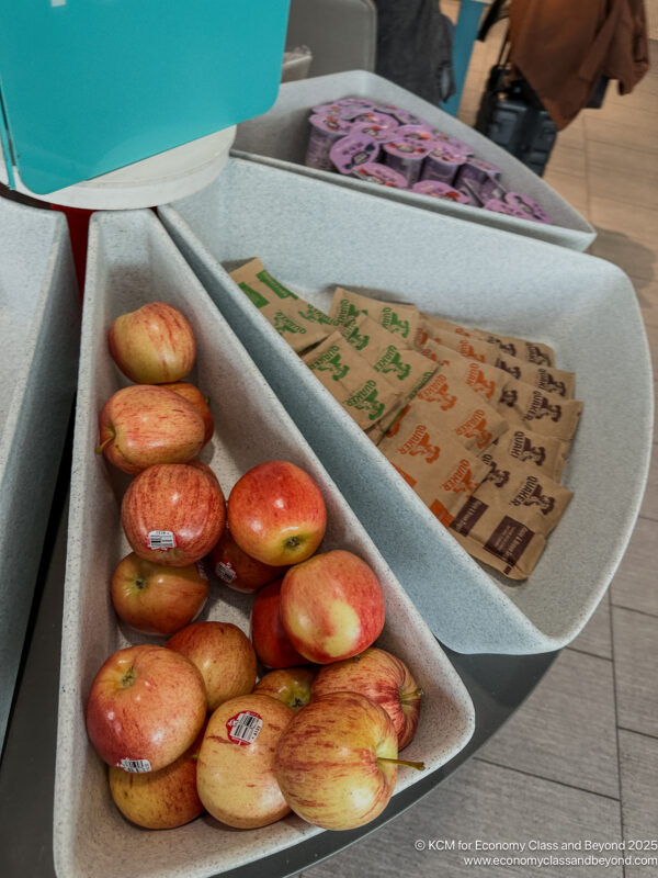 apples in a bowl with a packet of sugar and a bag of food