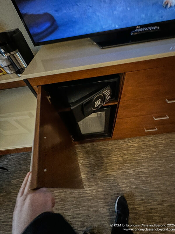 a hand opening a safe in a cabinet