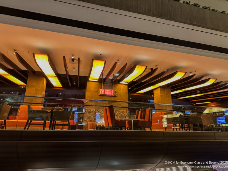 a glass wall with lights and tables and chairs