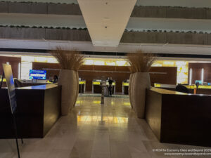 a lobby with tall vases of plants