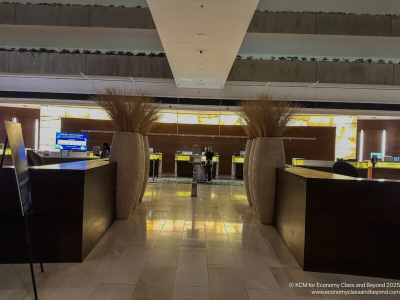 a lobby with tall vases of plants