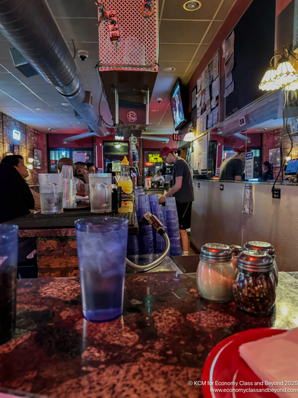 a bar with many glasses and a person standing behind it