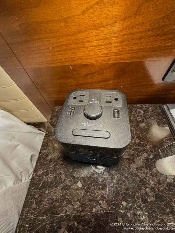 a square black device with a knob on a marble surface