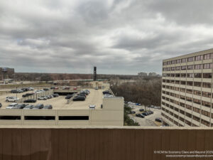 a parking lot with cars and buildings in the background