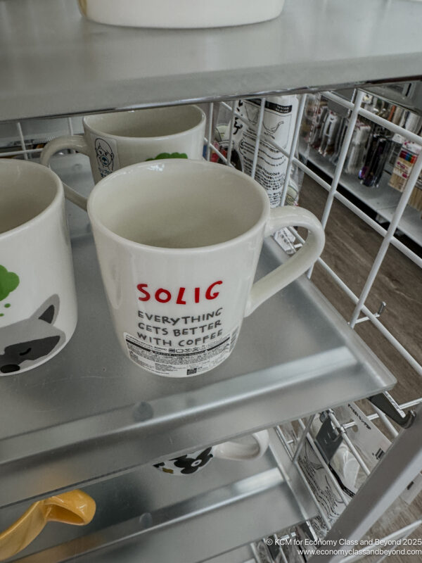a two white mugs on a shelf