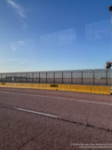 a road with a fence and a plant