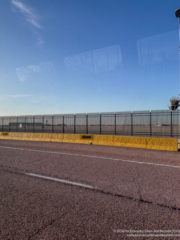a road with a fence and a plant